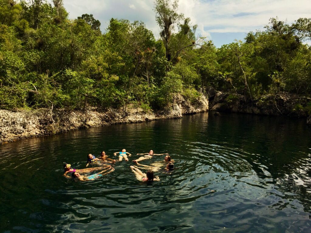 Students swimming and forming a circle while holding hands in the water