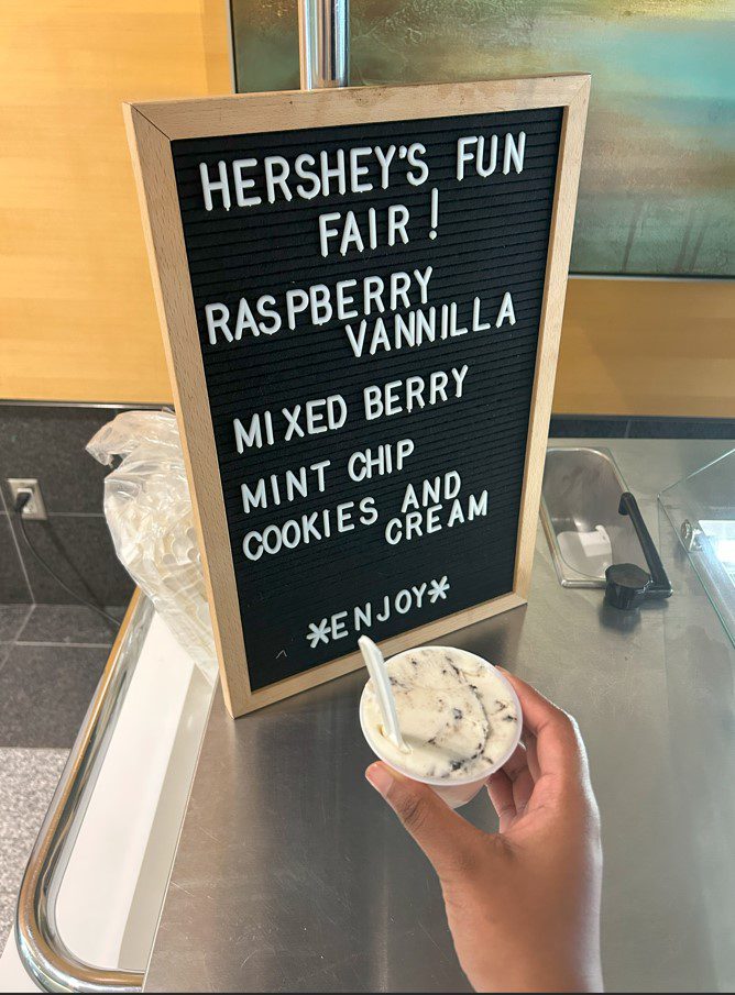 Hershey's Fun Fair sign with person holding cup of ice cream