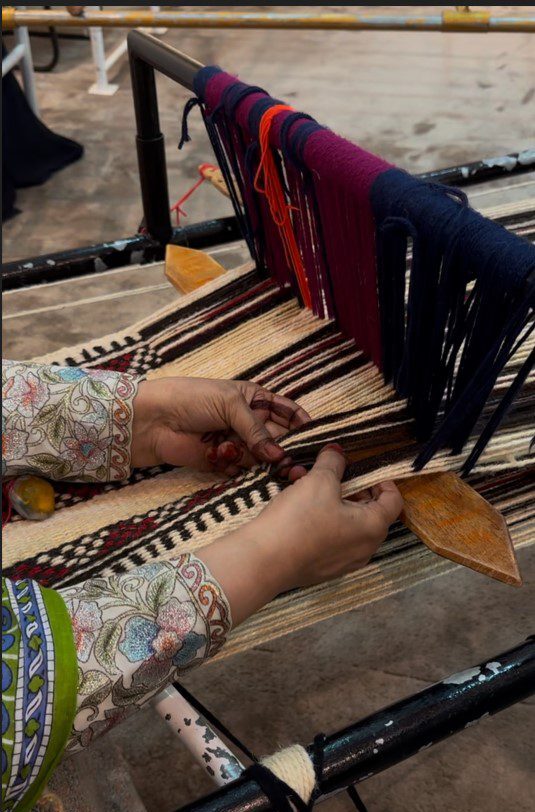 A woman hand-weaving fabric