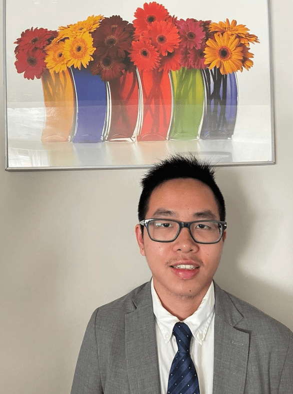 Kevin Nguyen in front of painting with flowers