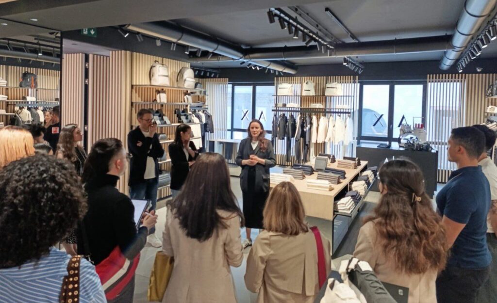 A person at Armani Exchange giving a presentation to students inside the retail store