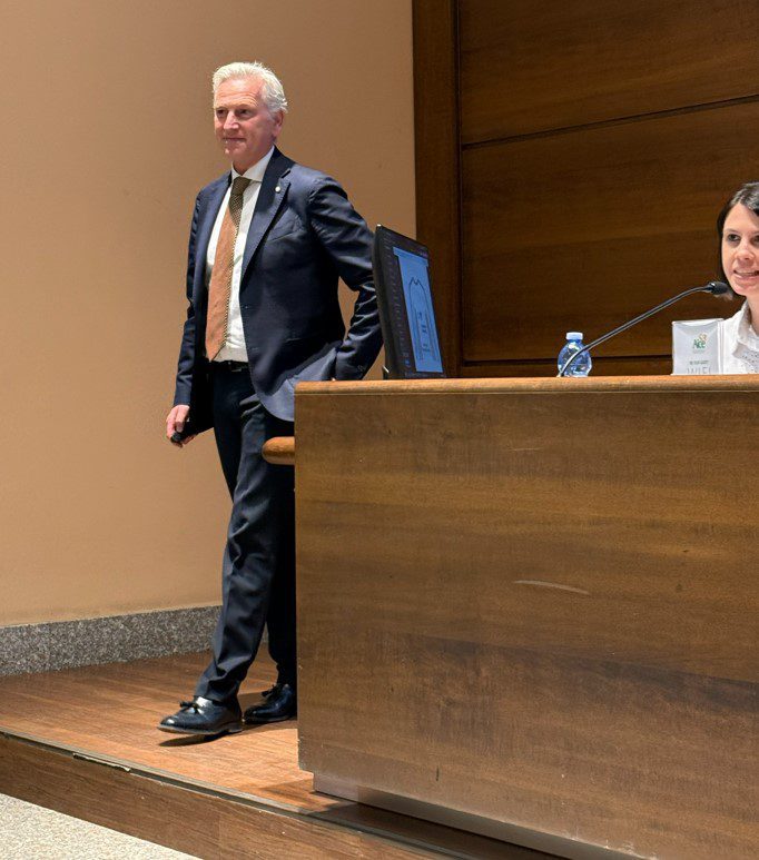 Man in a suit giving presentation in front of a room